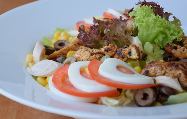 Image of Chef salad from Clay's salads menu which includes grilled chicken strips, tomatoes, eggs, olives, palmetto, and sweet corn.