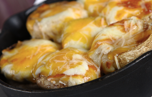 Image of fresh whole mushrooms with melted cheddar and mozzarella cheese from Clay restaurant's appetizers menu.