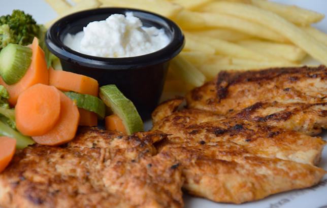 Image of grilled chicken breast with seasoned vegetables and fries from Clay's platters menu