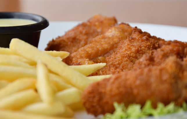 Image of four fried breaded chicken strips with fries from Clay restaurant's dine-in and delivery menu