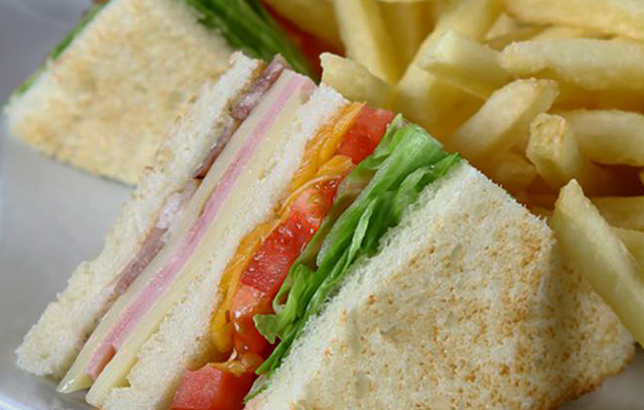Image of turkey or ham club sandwich with cheese, tomato, and lettuce from Clay restaurant