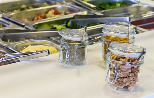Image of Clay restaurant's salad bar varieties including thyme, walnuts, raisins, cucumbers, cheese, shrimps, watermelon, and more.