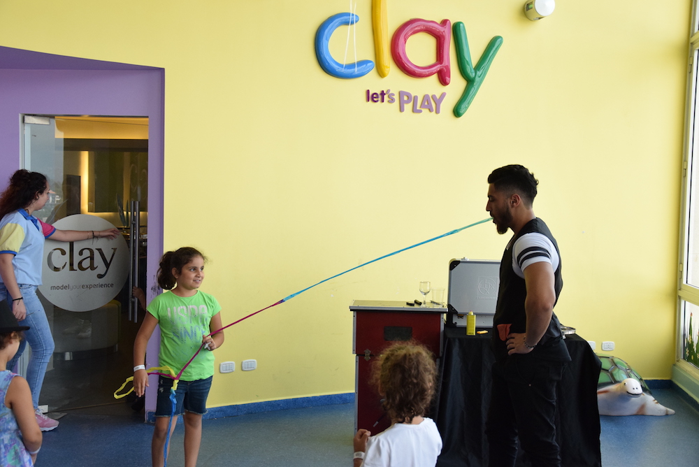 Image of a magician playing tricks with kids