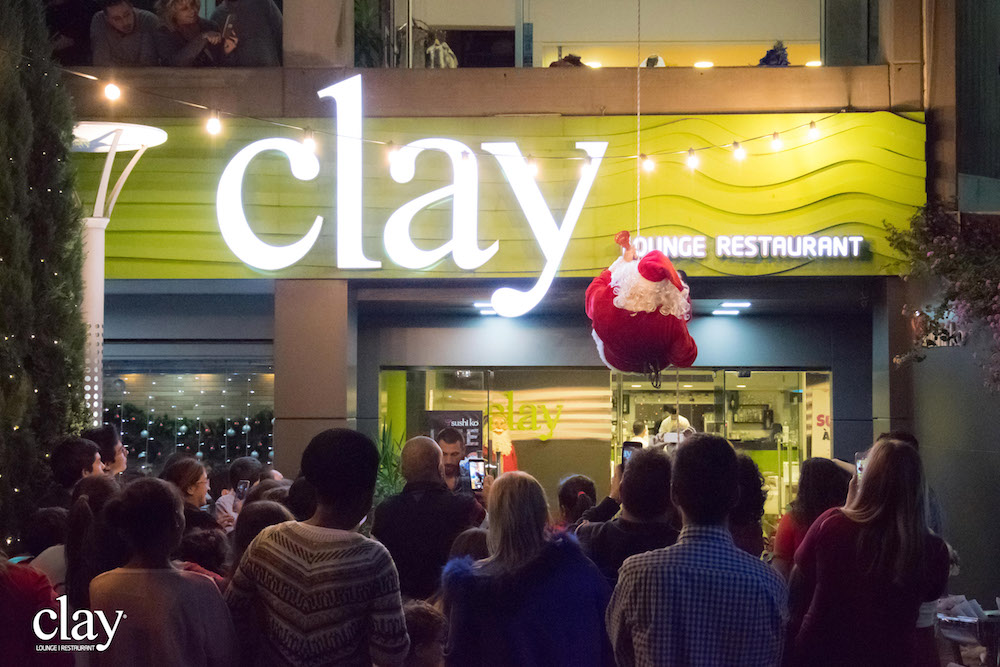 Image of Santa Claus rappelling down Clay's entrance during the Christmas kids event in 2017